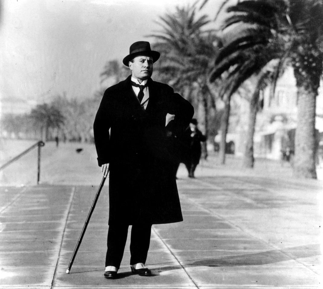 Итальянский диктатор Бенито Муссолини (1883-1945) в гетрах и пальто на бульваре в Биаррице, Франция. Итальянский диктатор Бенито Муссолини в гетрах и пальто на бульваре.