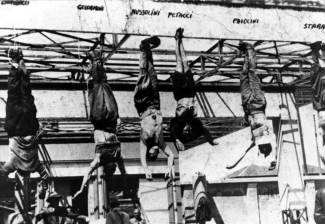 Труп лидера итальянских фашистов Бенито Муссолини (1883–1945) висит у его ног на заправочной станции в Милане после его казни партизанами в Меццегре 29 апреля 1945 года. Слева направо на фотографии трупы помечены как Никола. Бомбаччи, Гелормини, Муссолини, его любовница Клара Петаччи, Алессандро Паволини и Ахилле Стараче. Другие источники утверждают, что человек слева от Муссолини был Стараче. Труп лидера итальянских фашистов Бенито Муссолини.