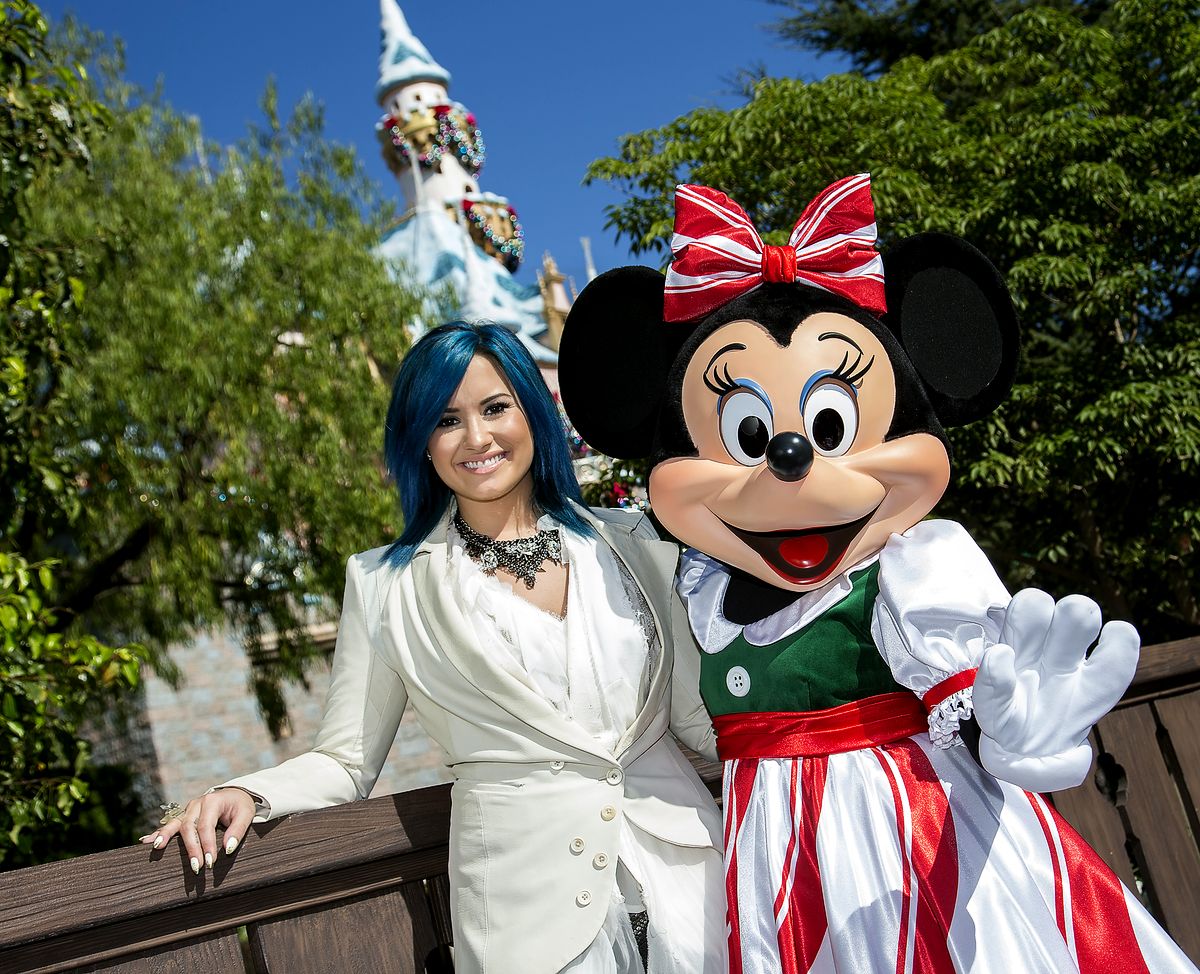 Деми Ловато с Минни Маус во время съемок телевизионного шоу «Disney Parks Christmas Day Parade» в Диснейленде в Анахеме, 9 ноября 2013 г. Деми Ловато с Минни Маус во время съемок телевизионного шоу «Disney Parks Christmas Day Parade»